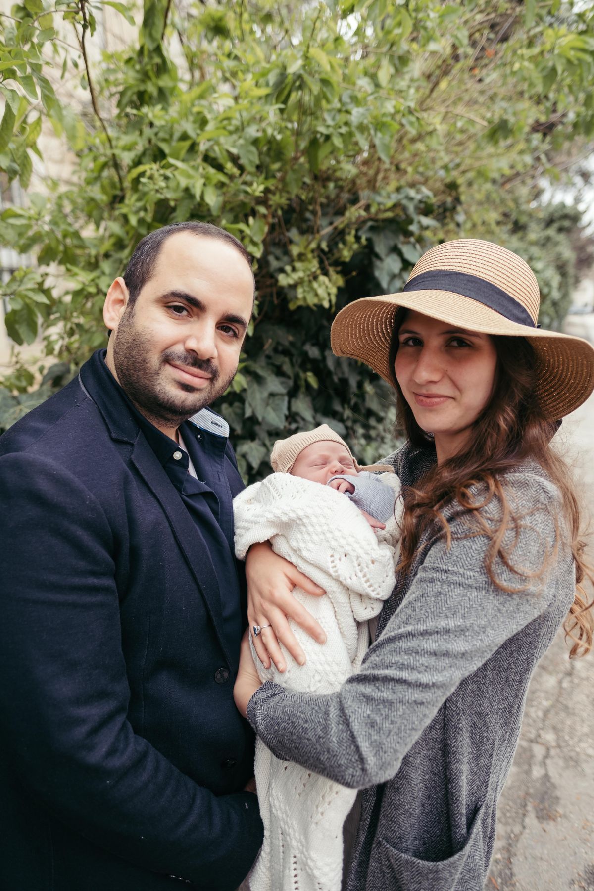 Parents holding their newborn son after his brit milah