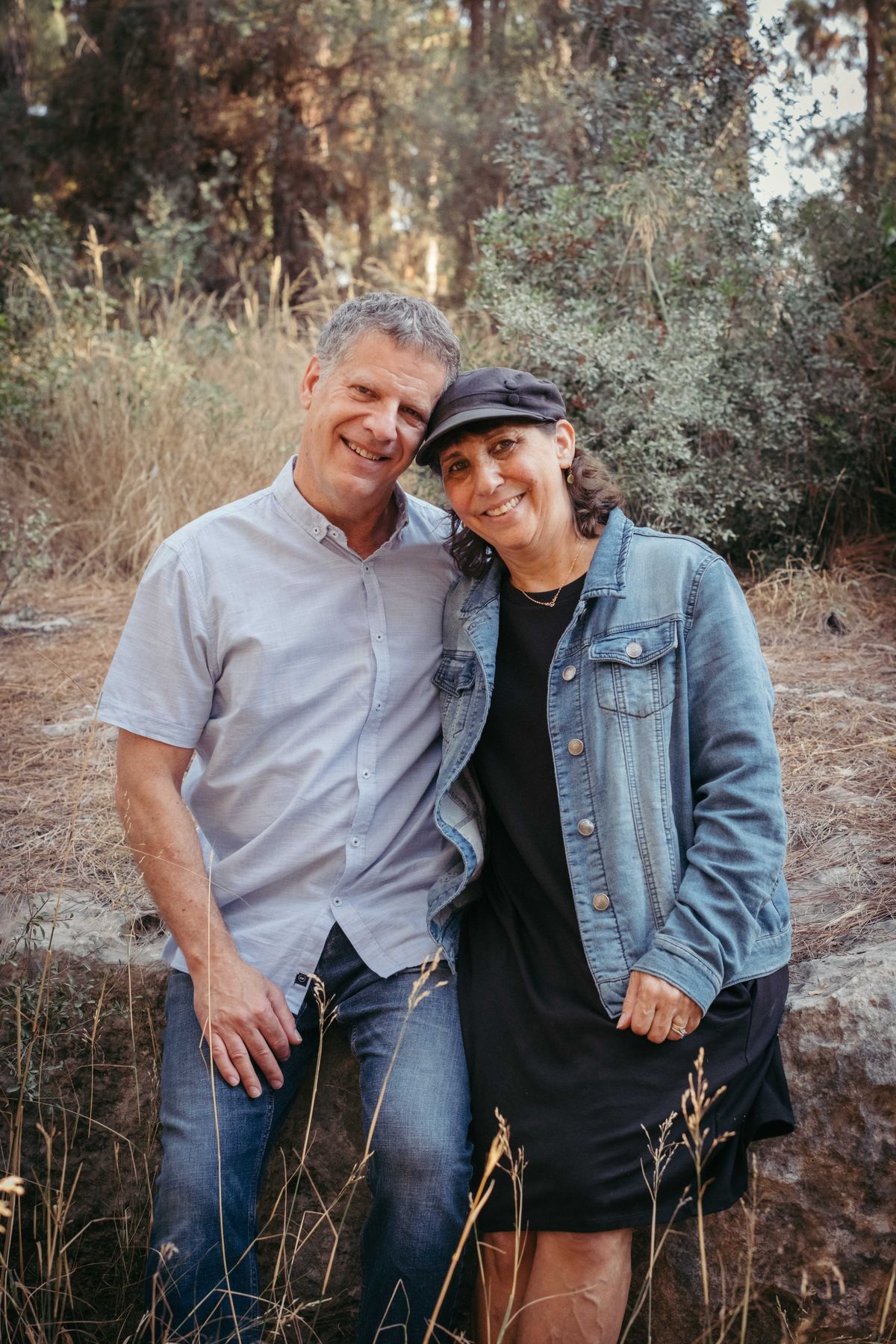 Couple leaning together among trees